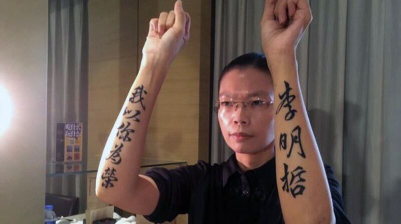 李妻李净瑜2017年9月11日赴陆会见丈夫,在双臂刺青“李明哲我以你为荣”力捍丈夫尊严。(资料照、李明哲救援大队提供)