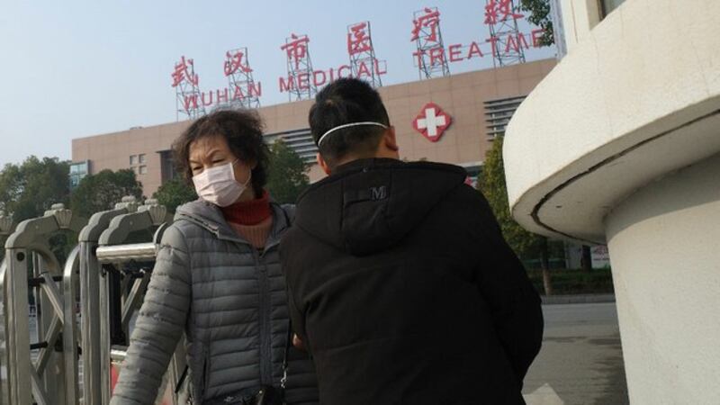 两名市民离开湖北省武汉市医疗救治中心。一名肺炎患者2020年1月12日在该中心死亡。(法新社)