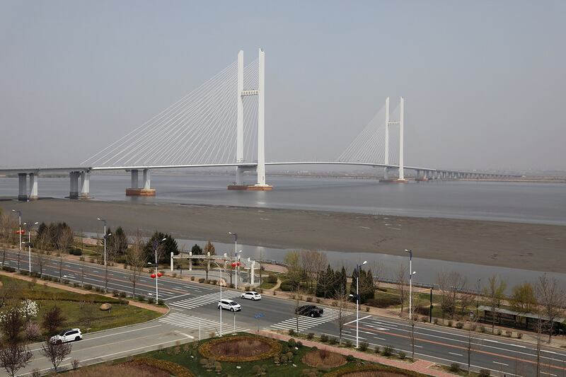 车辆行经辽宁省丹东市新鸭绿江大桥附近的公路,此桥联结了中国的丹东市与朝鲜的新義州市。(路透社资料图片)